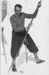 narciarz smarujący drewnianą nartę