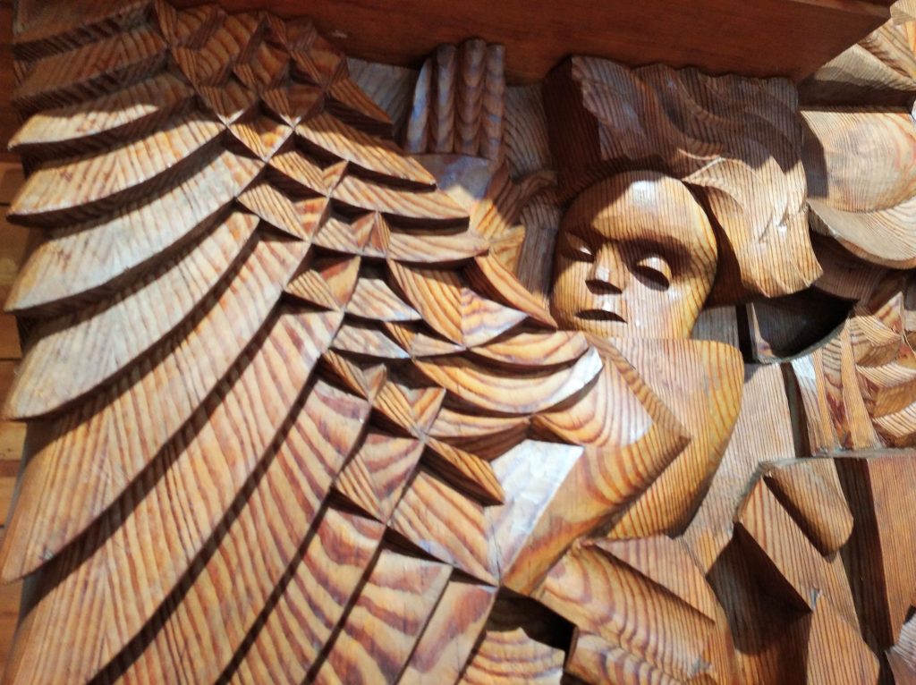 drewniana płaskorzeńba, skrzydła, twarz dziecka