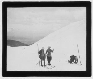 kobieta i mężczyzna ze starym sprzętem narciarskim w górach