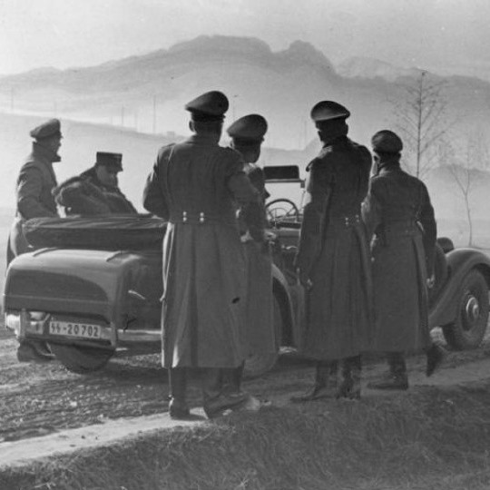 czarno białe zdjęcie. Żołnierze niemieccy stoją wokół auta. w tle Giewont