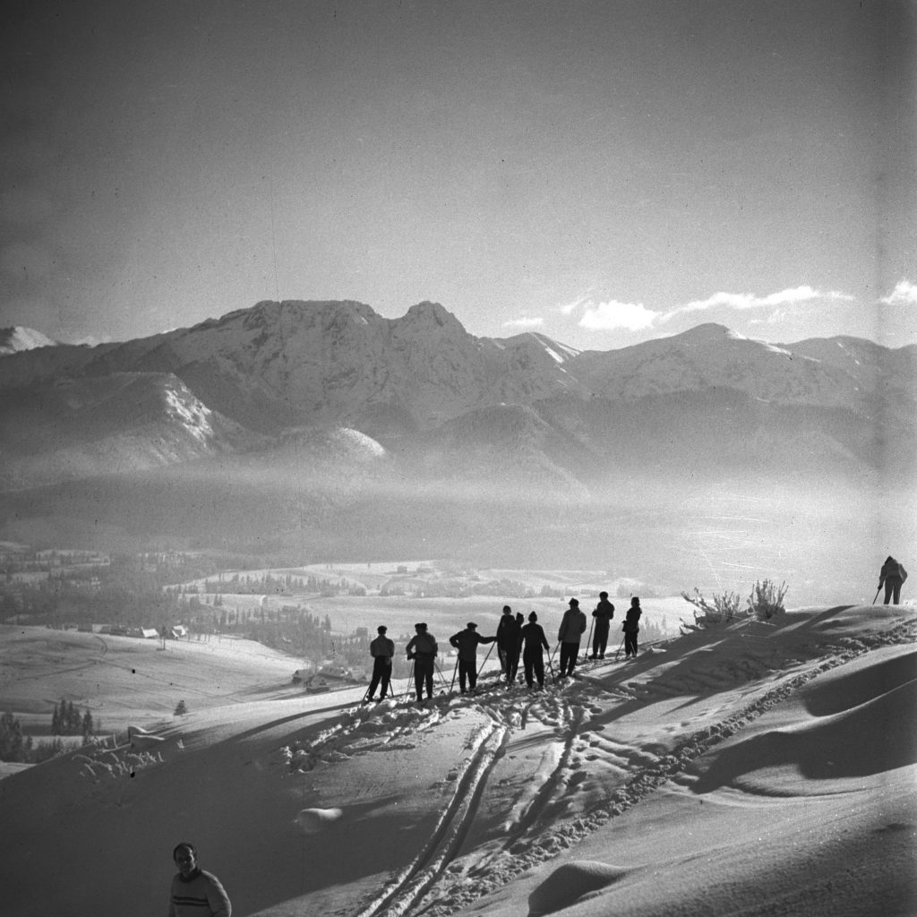 czarno biały pejzaż tatrzański na pierwszym planie narciarze w głębi Giewont
