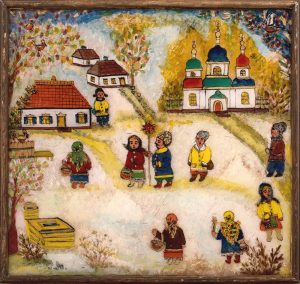 kwadratowy obrazek na szkle przedstawia kolorowo ubranych ukraińskich kolędników, w tle widzimy chaty i cerkiew