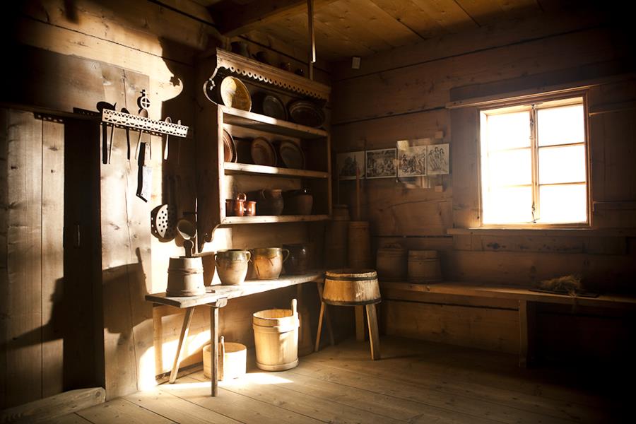 Fotografia starej góralskiej izby, naczynia drewniane na półkach - filia muzeum Zagroda Bafiów w Chochołowie