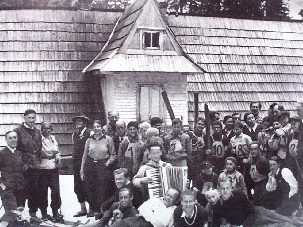Czarno-biała fotografia zawodników, zawody Pyszna 1937 r. na tle schroniska Pyszna