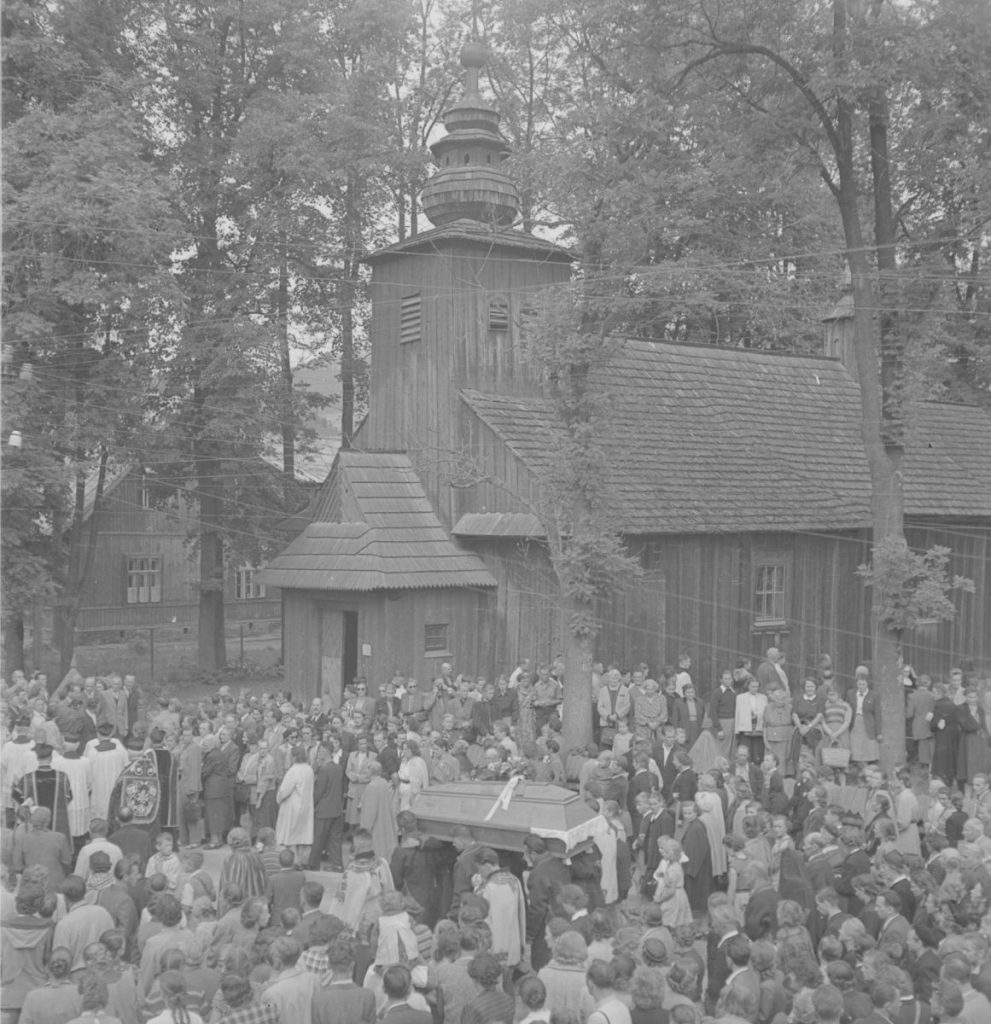 czarno-białe zdjęcie przedstawia pogrzeb Makuszyńskiego - trumna wśród tłumu ludzi zgromadzonych przed tzw. starym kościółkiem w Zakopanem