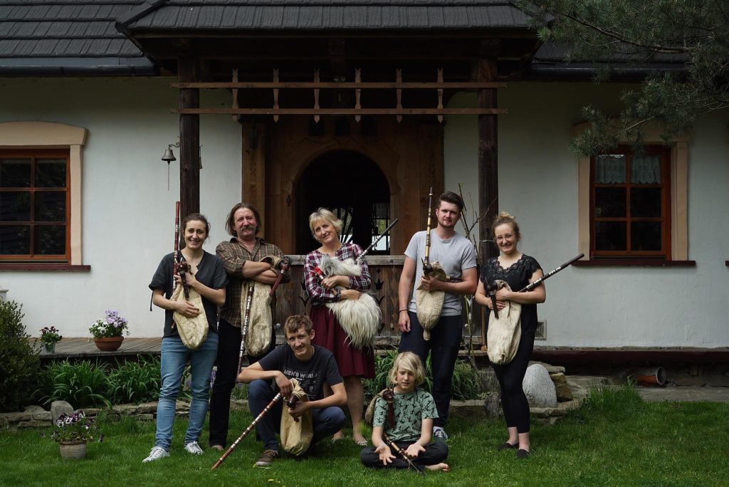 Rodzina Majerczyków wraz z instrumentami muzycznymi na tle białego domu
