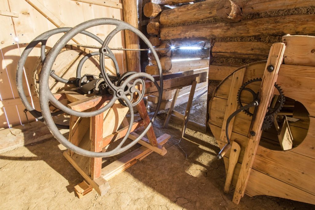 Na fotografii widzimy drewniane maszyny do młócenia zboża znajdujące się w Zagrodzie Korkoszów