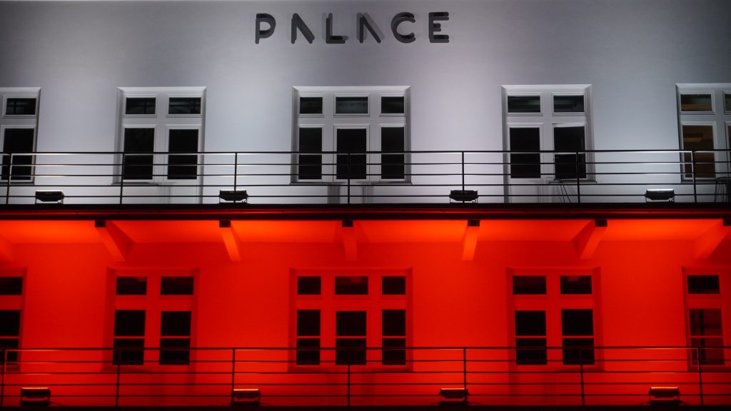 Fragment fasady nowo otwartego Muzeum Palace, który został podświetlony na białocerwono. W górnej centralnej części fotografii znajduje się napis ,,PALACE"