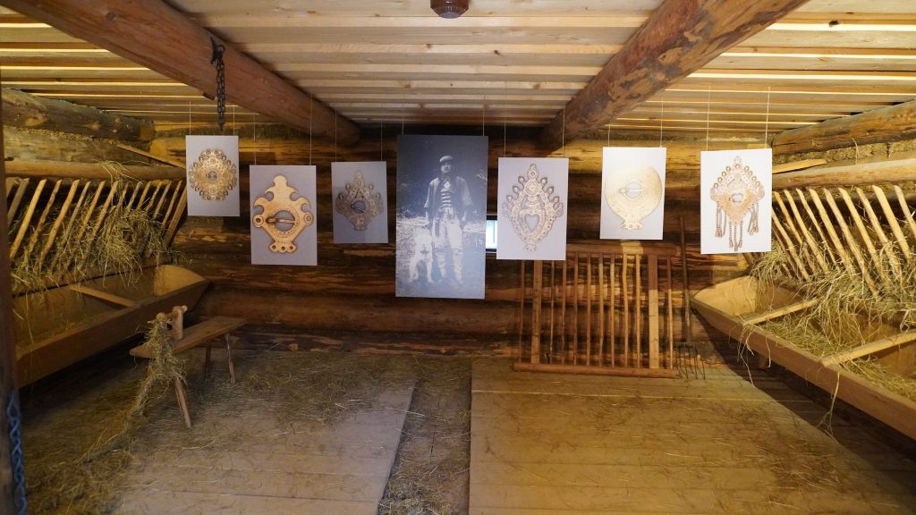 Część wystawy ,,Barwy Spisza" Na zdjęciu widzimy grafiki spinek góralskich i zdjęcie górala znajdujące się w centralnej części wystawy.