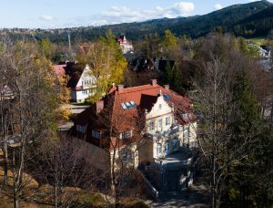 Widok z góry na drzewa budynki i góry, na pierwszym planie Galeria Sztuki im. W. J i A. Kulczyckich, Droga na Koziniec 8