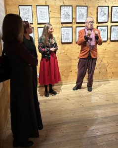 Na zdjęciu kuratorzy wystawy - Marek Krzysztof Lasecki i dr Emilia Pomiankiewicz-Wagner, tłumaczka języka migowego oraz Pani na tle rysunków prezentowanych na wystawie „SpotkajMY się w MT”.